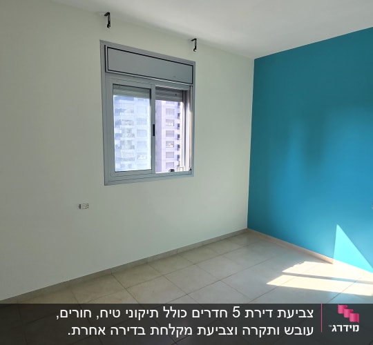 קיר צבוע בצבע טורקיז בחדר ריק עם חלון